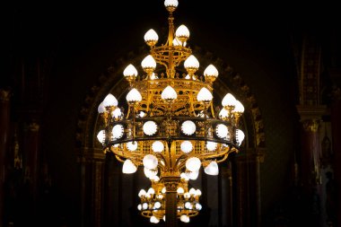 Koyu arkaplanda altın yaldızlı eski bir avize.