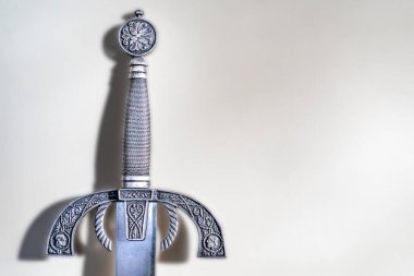 Hafif arkaplanı olan süslü metal kılıç kabzası