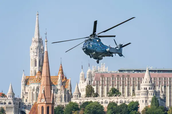 BUDAPEST, HUNGARY - 20 Ağustos 2024: Macar Hava Kuvvetleri H225M askeri helikopteri Macaristan Ulusal Günü 'nde tarihi Budapeşte şehir merkezinde uçuyor.