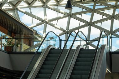 Metal mimari üçgen desenli, cam pencereli ve yürüyen merdivenli modern bina.