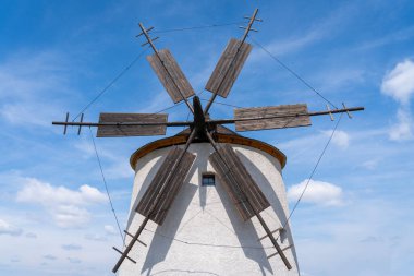 Arka planda mavi gökyüzü olan taştan yel değirmeni.