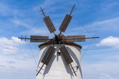 Arka planda mavi gökyüzü olan taştan yel değirmeni.