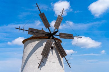 Arka planda mavi gökyüzü olan taştan yel değirmeni.