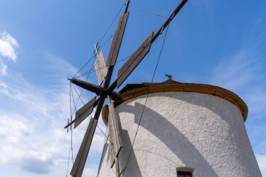Arka planda mavi gökyüzü olan taştan yel değirmeni.