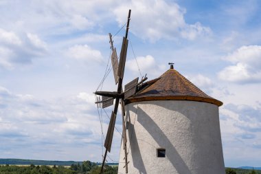 Arka planda mavi gökyüzü olan taştan yel değirmeni.