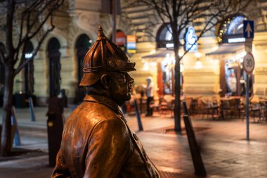 Bronz polis heykeli Budapeşte 'nin tarihi şehir merkezinde geceleyin şehir sokaklarını gözlüyor