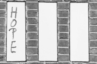 Üç beyaz alçı panelli kırmızı tuğla bir duvar. Ortasında el boyaması 