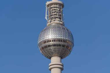 Berlin TV Kulesi 'nin (Fernsehturm) metalik küreye ve üzerindeki iletim platformuna odaklanan yakın çekim ürünü. Görüntü açık bir günde, parlak bir mavi gökyüzü ve görünür bir önplanı olmadan çekildi..