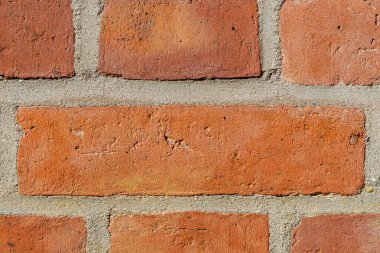 Sert yüzeyi ve görünür havan hatları olan eski kırmızı tuğla duvara yakın çekim.