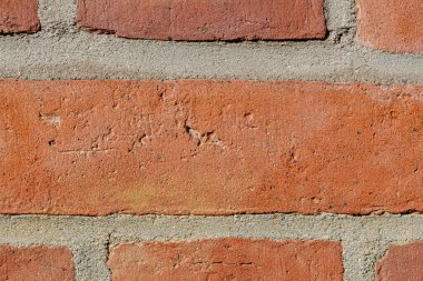 Sert yüzeyi ve görünür havan hatları olan eski kırmızı tuğla duvara yakın çekim.