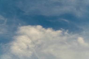 Kümülüs ve sirrus bulutlarının karışımı yumuşak mavi bir gökyüzünde sürüklenir..