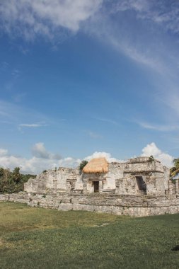 Tulum, Quintana Roo, Meksika 'da çekildi. Çimenli ovalarda saman çatısı olan taş yapılar var. Bu taş binalar Maya uygarlığının geride bıraktığı antik kalıntıların bir parçası.