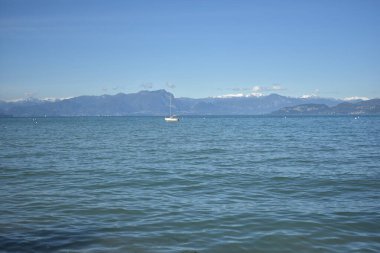 Peschiera del Garda 'daki sahile, İtalya' daki Garda Gölü 'ne, sakin sulara, arka planda dağlara
