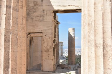 Atina Yunanistan: Nisan 2025. Propylaea 'nın Antik Sütunları, uzak bir kent görüşü olan Atina Akropolü' nün çerçevesi.
