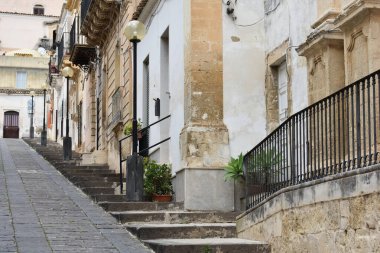 Akdeniz 'de dar, boş bir sokak, eski evler, Noto, Sicilya. Noto 'nun eski caddesi. Noto caddesindeki binalar. Sokak fotoğrafçılığı. İtalya 'da tatiller. Sicilya 'yı gezmek. Yalnızlık. 