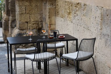 Sokak restoranı masası, boş kafe masası, açık hava restoranı, yaz sokak masası. İtalya, Sicilya ve Noto 'da bir aperatiften sonra boş bardaklarla dolu boş bir masa.. 