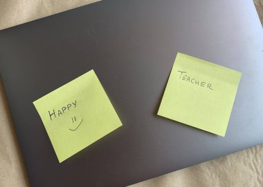 İş yeri. Çevrimiçi eğitim kavramı. E-öğrenme. Online eğitim. Laptop ve yapışkan notlar, el yazısıyla yazılmış öğretmenler ve mutlu, üst görünüm, kopyalama alanı, afiş. Modern çalışma ortamı.