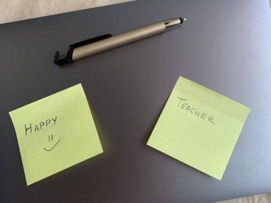 İş yeri. Çevrimiçi eğitim kavramı. E-öğrenme. Online eğitim. Laptop, kalem ve yapışkan notlar, el yazısıyla yazılmış öğretmenler ve mutlu, üst görünüm, kopyalama alanı, afiş. Modern çalışma ortamı.