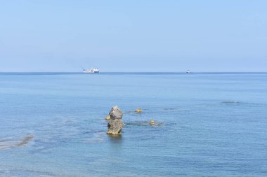 Spiaggia di Settefrati: Cefalu yakınlarında plaj, Sicilya, İtalya. Deniz, kayalar ve uzaktan bir gemi. Doğal bileşim. Seyahat ve turizm konsepti. Sicilya 'da tatiller. İtalya 'ya seyahat. 