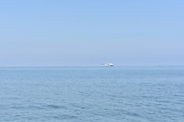 Spiaggia di Settefrati: Cefalu yakınlarında plaj, Sicilya, İtalya. Deniz, gökyüzü ve uzaktan bir gemi. Doğal bileşim. Seyahat ve turizm konsepti. Sicilya 'da tatiller. İtalya 'ya seyahat. 