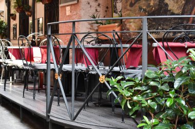 Sokak restoranı masaları, boş kafe masaları, bistro koltukları, bar terası, açık hava restoranı, kafeterya. Castelbuono caddeleri ve binaları, Sicilya Adası, İtalya. Eski Sicilya köyü. Palermo Eyaleti. Seyahat ve turizm kavramı