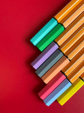 Ofis ve çalışma için renkli kalemler. Renkli arka planda bir sürü renkli işaret var, düz bir zemin. Okul kırtasiyesi. Çalışma, ofis ve çizim konsepti. 