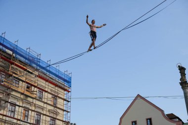 Şehrin yüksek caddelerinde dengede duran berduş bir yolcu iskelesi ve arka planda şehir binaları olan açık mavi bir gökyüzü. Şehir macerası ya da ekstrem spor temaları için mükemmel.