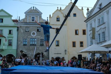 Hareketli bir kalabalık ve tarihi mimarinin canlı, kültürel bir zemin oluşturduğu Avrupa şehir meydanındaki dinamik gevşek çizgili performans. Kentsel ya da seyahat temalı görseller için mükemmel