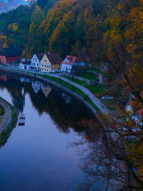 Sonbahar ormanı, nehir kenarındaki evler ve akan su manzaralı nehir manzarası..