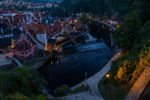 Aydınlatılmış evleri, sakin nehri, küçük barajı ve tarihi şehir manzarası olan eski şehrin akşam manzarası.