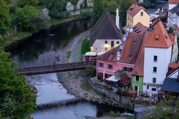 Kırmızı çatıları, ahşap bir köprüsü ve tarihi Avrupa kasabasında sakin bir nehri olan büyüleyici nehir kenarı manzaralı evler..