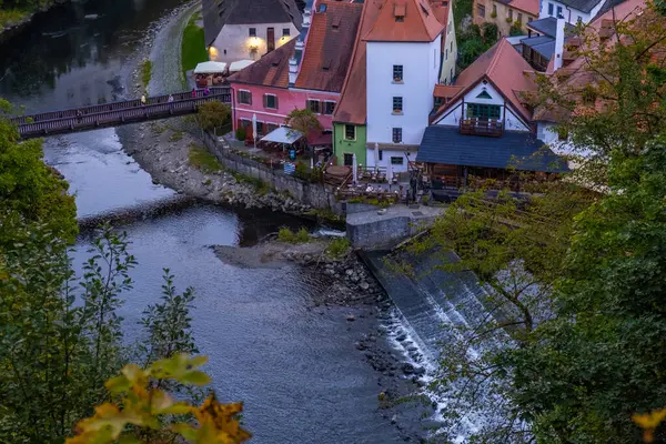 Kırmızı çatıları, ahşap bir köprüsü ve tarihi Avrupa kasabasında sakin bir nehri olan büyüleyici nehir kenarı manzaralı evler..