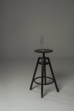 Stüdyoda siyah bir sandalye ve üzerinde şeffaf bir cam. Yüksek sandalye, siyah ve yuvarlak koltuk..