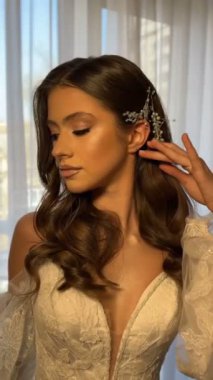 Siyah saçlı ve mavi gözlü güzel ve çekici bir gelinin portresi. Yüzünde makyajlı, gülümseyen ve kameraya bakan esmer bir kadının yüzünü kapatın.