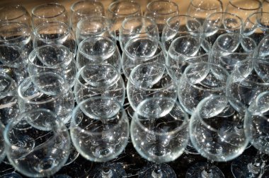 Gündüz vakti arka planda bir sürü boş temiz şarap kadehi. Şarap kadehleri, bar, bardak, sıralar, boş bardak. Siyah arka planda şarap bardakları yakın plan..