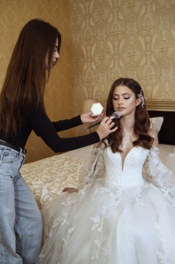 Profesyonel makyöz evde genç gelinle çalışıyor. Yüksek kalite fotoğraf