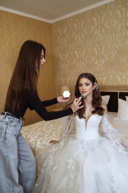 Zarif gelin nikah gününde son makyaj dokunuşunu yapıyor. Kusursuz bir düğün görüntüsü için makyajını yaptıran çarpıcı bir gelin. Güzel bir gelin özel günü için son dokunuşları alıyor..