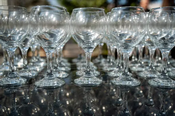 Gündüz vakti arka planda bir sürü boş temiz şarap kadehi. Şarap bardakları, bardaklar, bardaklar, sıralar, boş bardaklar, şeffaf, cam. Siyah arka planda şarap bardakları yakın plan..