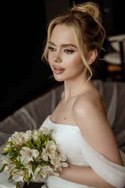 Çiçekli güzel gelin buketi, gelinlikli çekici kadın. Yeni evli ve mutlu bir kadın. Düğün makyajlı ve saç stili gelin. Göz kamaştırıcı gelin, profilde portre, 