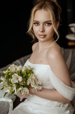 Çiçekli güzel gelin buketi, gelinlikli çekici kadın. Yeni evli ve mutlu bir kadın. Düğün makyajlı ve saç stili gelin. Gelin kameraya bakar.