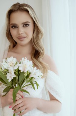 Gelin elinde bir buket tutuyordu. Zarif beyaz düğün buketi. Gelin elinde bir buket zambak tutuyor. Yüksek kalite fotoğraf