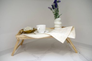 Sabah kahvesi ve çiçekli ahşap tepsi. Işıl ışıl bir kabın içinde. Yüksek kalite fotoğraf. Masadaki bir vazo çiçek. Yüksek kalite fotoğraf