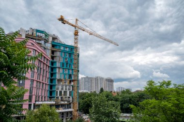 Bir binanın inşaatında kule vinci. Konut inşaatında inşaat vinci. Çok katlı binaların inşaatı için inşaat alanı. Kasaba evlerinin modern inşaatı