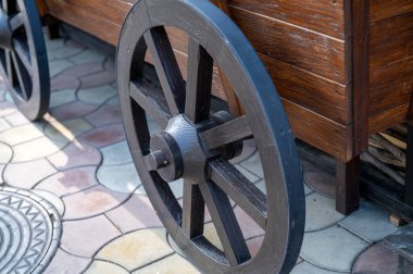 Köy tarzında ahşap tekerlek ve el arabası sokağı süsler. Araba üstüne araba, sokak dekorasyonu. İşçiliği ve tarihsel önemi gösteriyor. Yüksek kalite fotoğraf.