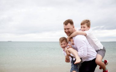 Babam sahilde omuzlarında iki oğul taşıyor. Baba ve oğulları sahilde birlikte yürüyorlar. Baba ve oğulları gün içinde kumsalda oynayıp eğleniyorlar. Arkadaş canlısı aile kavramı