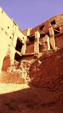 Amezrou, Fas, 15 Kasım 2024: Amezrou, Zagora Eyaleti, Fas 'taki Yahudi Kasbah kalıntıları, dikey renkli fotoğraf. Harap olmuş kerpiç binaları görülebiliyor. Kırmızımsı kahverengi kilden yapılmış yıkılan binaların yakın çekim görüntüsü.