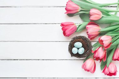 Beyaz ahşap sırtında laleleri olan mavi bülbül yumurtalı kuş yuvası