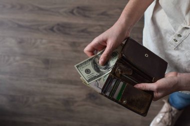 Amerikan dolarlarıyla cüzdanı tutan kadın.