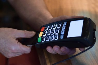 Perakende mağazasında ödeme terminali kullanan kişiler