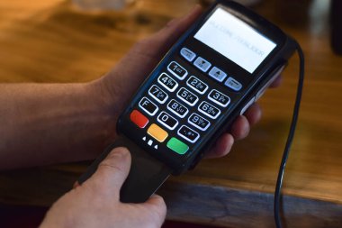 Perakende mağazasında ödeme terminali kullanan kişiler